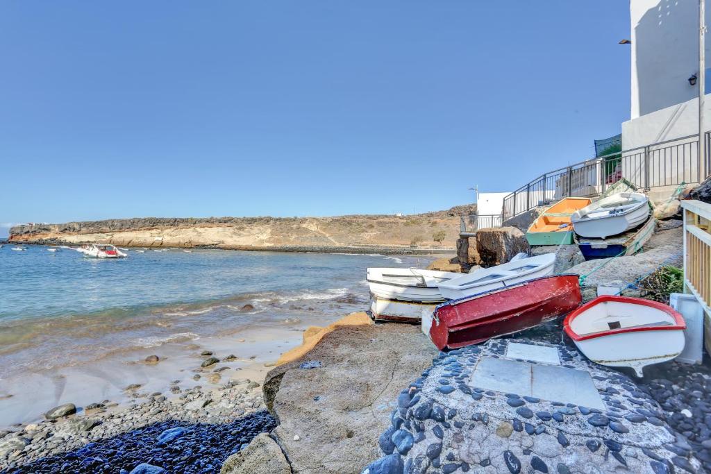 La Casa del Capitán - beach-colorful-dinghies-on-rocks
